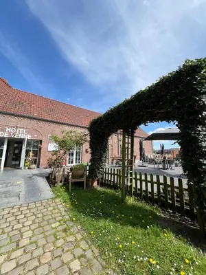 an ivy covered fence in front of a building at Hotel De Venne in Genk
