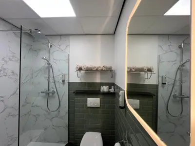 a bathroom with a shower and a toilet at Hotel De Venne in Genk