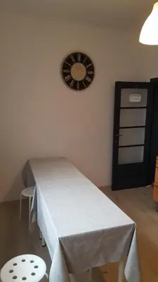 a room with a table and a clock on the wall at Leonard room in Liège
