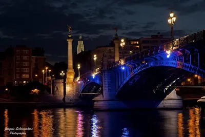 a blue bridge over a river at night at Studio des jardins suspendus in Liège