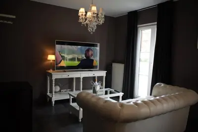 a living room with a television and a couch at L'écrin des Vennes - Liège centre in Liège