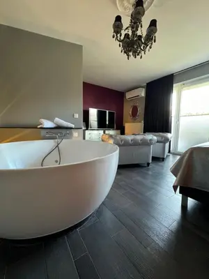 a living room with a large white tub in a room at L'écrin des Vennes - Liège centre in Liège