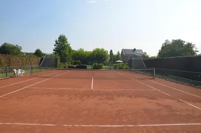 a tennis court with a net on top of it at B&B Serenity in Pelt