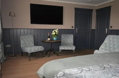 a bedroom with a bed and two chairs and a table at B&B Serenity in Pelt