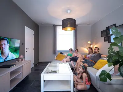 a group of people sitting on a couch in a living room at Vakantiewoning Mierzicht - privé wellness - Haspengouw 6p in Boekhout