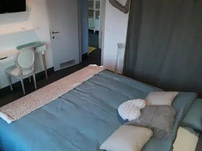 a bedroom with a blue bed with pillows and a desk at Villa Marco 176 in Cerexhe-Heuseux