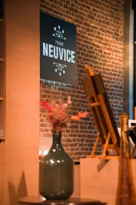 a vase with flowers in it sitting on a table at Hotel Neuvice in Liège
