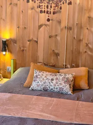 a bedroom with a bed with a wooden wall at Hemelse Helderheid in Maasmechelen
