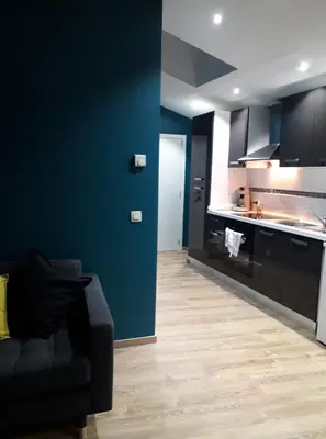 a living room with a couch and a kitchen at Chez Vivi in Ans