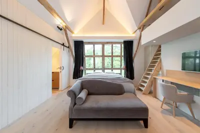 a bedroom with a bed and a couch at Winning De Zwaen in Hasselt