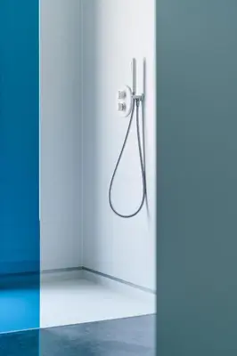 a shower in a white bathroom with blue walls at B&B Bed and Beyond in Oudsbergen