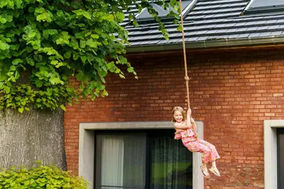 a young girl is swinging on a tree swing at B&B Bed and Beyond in Oudsbergen