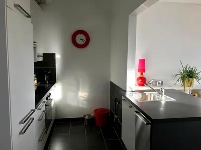 a kitchen with a sink and a clock on the wall at De tuin van Agatha in Kortessem