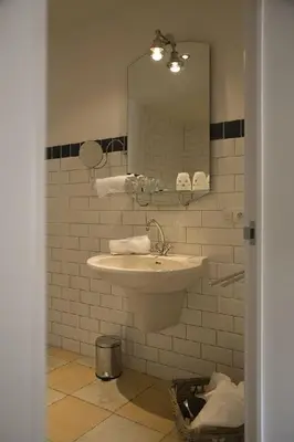 a bathroom with a sink and a mirror at Auberge 's Gravenhof in Voeren