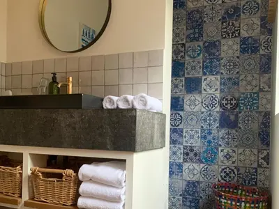 a bathroom with a sink and a mirror and towels at Vakantiehuis ABEL in Dilsen-Stokkem