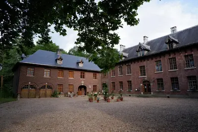 a large red brick building with a large courtyard at Het Domherenhuis B&B, Restaurant Calice in Heusden - Zolder
