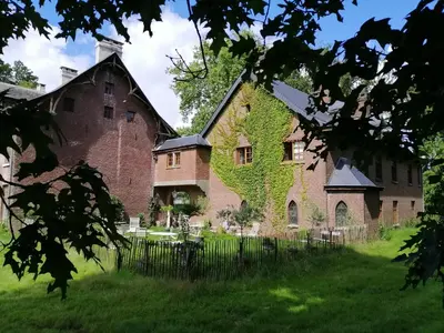 an old brick building with ivy growing on it at Het Domherenhuis B&B, Restaurant Calice in Heusden - Zolder