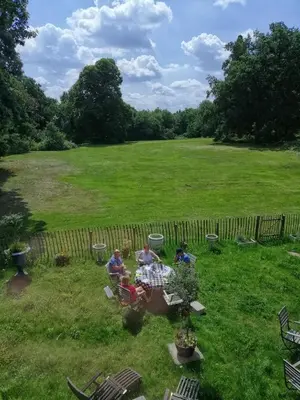 a group of people sitting around a table in a yard at Het Domherenhuis B&B, Restaurant Calice in Heusden - Zolder