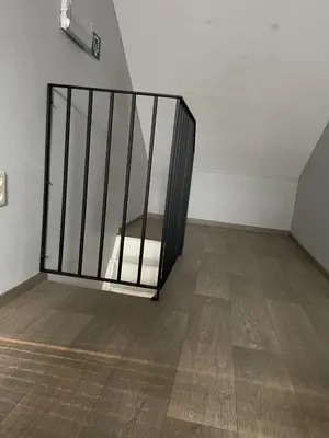 a metal gate in a room with a wooden floor at Vakantiewoning Bij de Jep in Bilzen