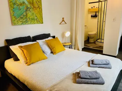 a bed with yellow pillows and two towels on it at L’atelier St Remacle in Liège