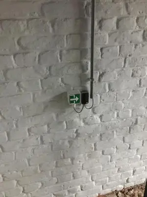 a white brick wall with a light on it at L’atelier St Remacle in Liège