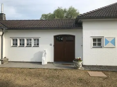 a small white house with a brown door at Landhaus Sylvia in Eupen, Terrasse , Garten & Nähe zum Hohen Venn in Eupen