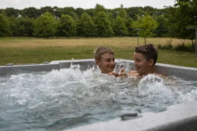 two young boys playing in a hot tub at Vakantiewoning Heidebos in het Nationaal Park Hoge Kempen in Het Laar