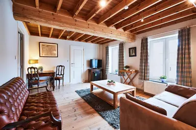 a living room with a couch and a table at Wellness B&B De Zevenslaper in Geetbets