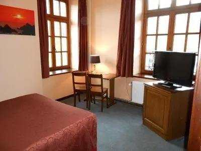 a bedroom with a bed and a tv and a desk at Hotel IL Castellino in Chaudfontaine