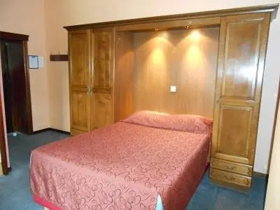 a bedroom with a bed and a wooden cabinet at Hotel IL Castellino in Chaudfontaine