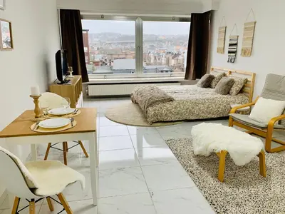 a living room with a bed and a table and chairs at Le Cocon d'Avroy in Liège