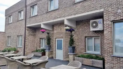 a brick building with tables and chairs in front of it at Belrom Hotel in Sint-Truiden