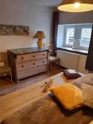 a living room with a wooden dresser and a couch at La Pause in Plombières