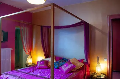 a bedroom with a canopy bed with purple sheets at Vip room 209 in Trooz