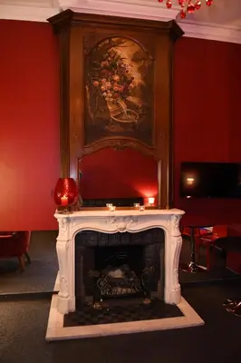 a fireplace in a room with a painting on the wall at Vip room 209 in Trooz