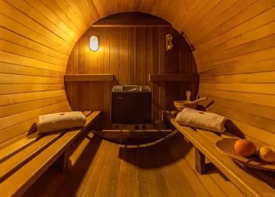 a sauna with two benches and a tv in it at Le Baiser de Shogun in Ensival
