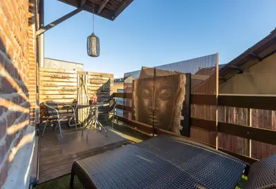 a patio with a table and chairs on a fence at Le Baiser de Shogun in Ensival