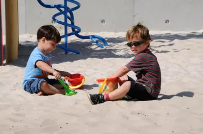 two young boys playing in the sand at the beach at Vakantiewoning Zavelbos in Maaseik
