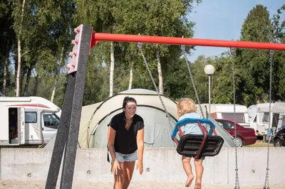 a man and a woman walking on a swing at Vakantiewoning Zavelbos in Maaseik