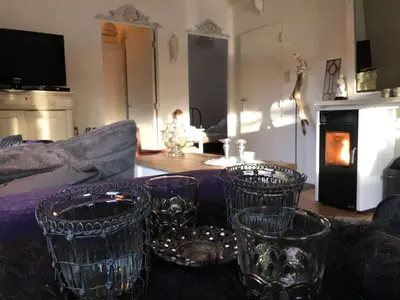 a living room with four clear glasses on a table at Chalet Sint Barbara in Zutendaal
