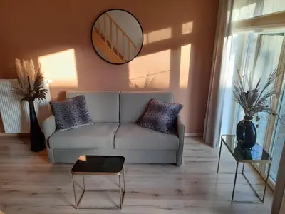 a living room with a couch and a mirror at B&B De Floreffe in Overpelt