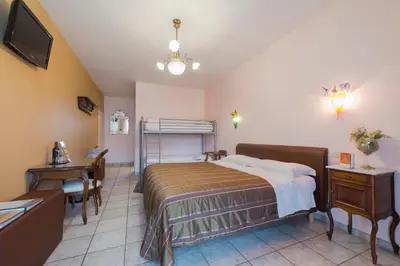 a bedroom with a bed and a desk and a television at B&B Casa Roman & Vakantiewoning voor 1 pers tot max 32 personen in Zonhoven