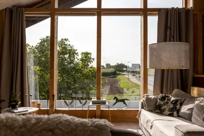 a living room with a couch and a large window at StroEnzo - RUIME LOFT - 5P - 2SLPK - DAKTERRAS - LAADPAAL - 10MIN Maastricht in Riemst