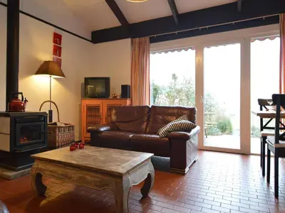 a living room with a leather couch and a coffee table at Holiday Home in Gemmenich with Forest Views in Ten Eiken