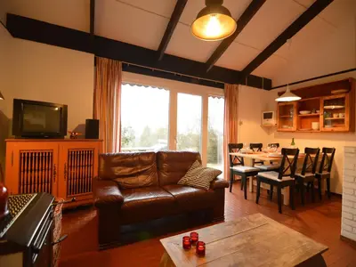 a living room with a leather couch and a table at Holiday Home in Gemmenich with Forest Views in Ten Eiken