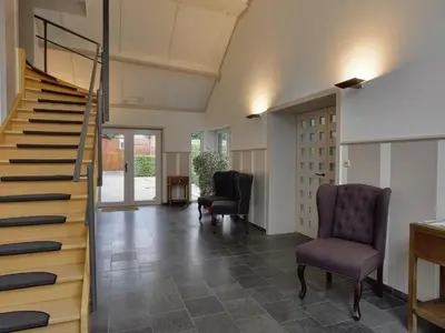 a hallway with two chairs and a staircase at Monastery Retreat in Blossoming Limburg in Sint-Truiden