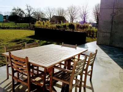 a wooden table and chairs on a patio at Dalhem Villa with Garden in Dalhem