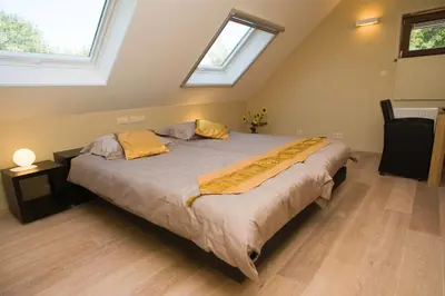 a large bed in a room with two windows at De kiezel in Hasselt
