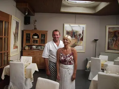 a man and a woman standing in a dining room at Hotel Hooghuys in Hamont-Achel