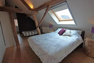 a bedroom with a large bed with a window at B&B Crijbohoeve in Zutendaal